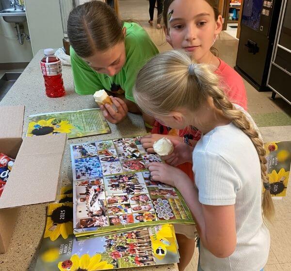 Children looking through the printed SIELA Camp Journal from Summer Camp 2025