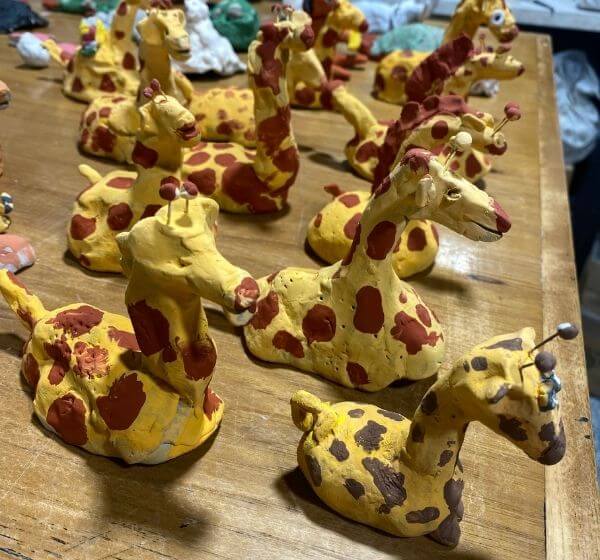 Handmade ceramic giraffe sculptures created by children at Siela Summer Camp 2025