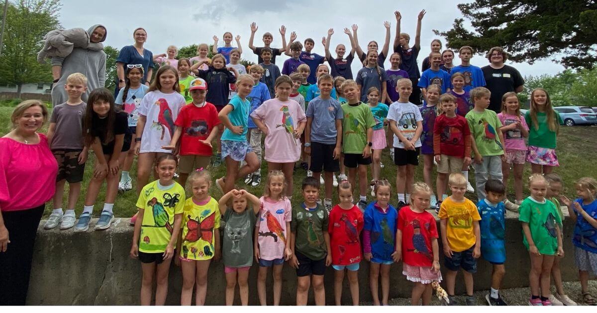 Full outdoor group photo of children and leaders at summer camp