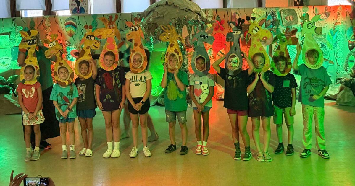 Children wearing giraffe-themed costume pieces during a creative group scene