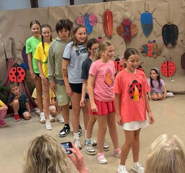 Children taking part in a group performance during a ladybug-themed activity at Siela Summer Camp 2025