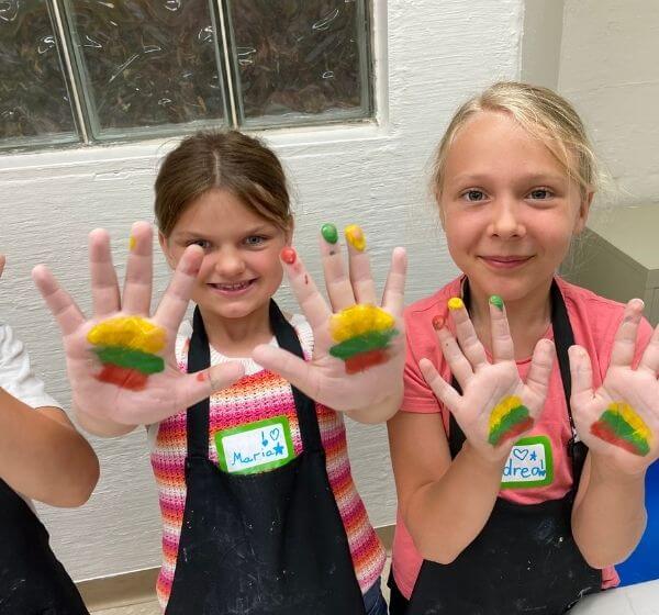 Two children showing painted hands during Siela Summer Camp 2025