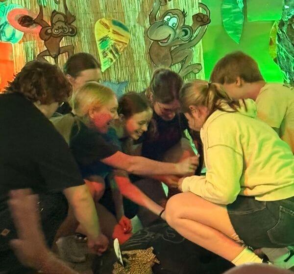 Children gathered together during an indoor team game at Siela Summer Camp 2025